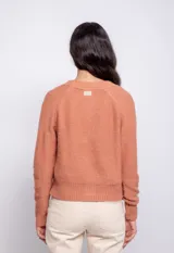 Cardigan color beige con trama de punto trenzado, cuello en V y cierre frontal con botones.