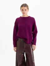 Sweater de punto con textura suave, de silueta relajada y largo por debajo de la cadera. Presenta cuello redondo, mangas largas y costuras laterales desplazadas hacia el frente.