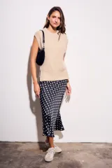 Falda midi de poliéster color negro con estampado de lunares blancos.