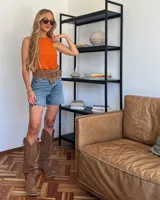 Botas de caña alta estilo western, confeccionadas en cuero negro, con taco cuadrado y detalle de tiradores laterales.