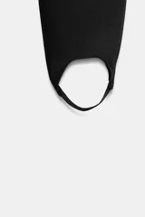 Leggings negros de tiro alto con banda elástica en la cintura y diseño tipo calza de esquí con estribo para el pie.