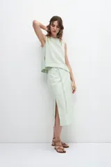 Falda midi verde manzana de lino, con corte recto, cintura alta y tajo lateral.
