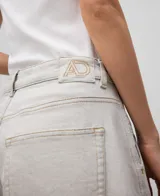 Pantalón palazzo de denim crudo para mujer, de tiro alto, con cierre de botón metálico, trabillas, bolsillos laterales y traseros, costura lateral desplazada al delantero de la pierna, pespuntes decorativos a contraste y parche logotipado en la espalda.