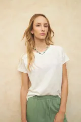 Remera blanca de manga corta, con cuello redondo y tejido de algodón con textura.