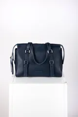 Cartera tipo bolso de mano y hombro de cuero color bordó, con diseño estructurado, doble asa corta y detalles de correas con hebillas metálicas en el frente.