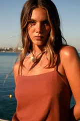 Vestido corto marrón de lino y rayón, con escote recto, tirantes finos y tajo lateral.