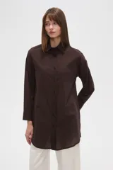 Camisa marrón holgada de algodón con cuello clásico, cierre frontal con botones y mangas largas con puños abotonados.