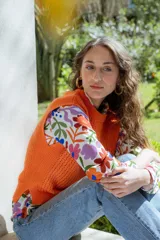 Chaleco tejido de punto calado en color naranja, con cuello redondo y diseño con hombreras.