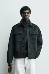 Sobrecamisa regular fit color verde oscuro, confeccionada en tejido efecto ante. Cuenta con cuello solapa, manga larga con puño abotonado, bolsillos de plastrón con solapa en el pecho y bolsillos de vivo en la cadera. El cierre es frontal con botonadura.