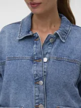 Campera de denim oversize de color celeste, modelo estilo shacket, con cuello clásico, cierre frontal con botones metálicos y amplios bolsillos delanteros.