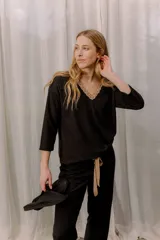 Pijama de algodón gris con textura acanalada, compuesto por una remera de manga larga con escote en V decorado con puntilla y un pantalón recto con elástico y lazo en la cintura.