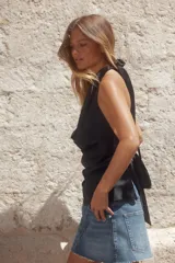 Top blanco de tejido satinado con cuello halter drapeado ajustable con lazada en el cuello y espalda descubierta con lazada.