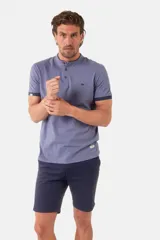 Remera de jersey con cuello mao y cierre frontal de tres botones. Presenta mangas cortas con terminación en contraste y un pequeño bordado en el pecho.