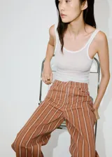 Jeans de corte recto y tiro medio con diseño de rayas verticales en tonos marrón y blanco.