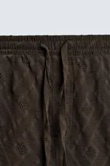 Bermuda de corte regular confeccionada en tejido fluido con textura jacquard geométrica. Presenta cintura elástica con cordón ajustable, bolsillos laterales y bolsillos traseros de vivo.