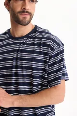 Remera oversize de manga corta confeccionada en algodón, con diseño de rayas horizontales en tonos azules y blancos.