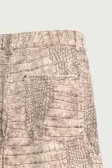 Pantalón relaxed fit de algodón con estampado animal print de cocodrilo en tonos beige y gris. Tiene diseño de cinco bolsillos, cierre frontal con cremallera y botón, y una tira con bolsillo multifunción en la pernera.