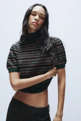Jersey de punto con cuello subido y manga corta, diseño a rayas horizontales en tonos verde oscuro, negro y rosado.