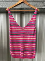 Musculosa de hilo de tejido punto con diseño a rayas horizontales multicolor sobre base fucsia y escote en V.