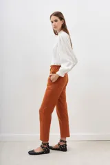 Pantalón sastrero color naranja quemado, de tiro alto con elástico fruncido en la cintura y corte recto/baggy.