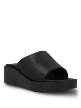 Sandalia tipo slide con plataforma, confeccionada en cuero negro liso. Cuenta con una plantilla de poliuretano moldeada para mayor amortiguación y suela liviana de poliuretano.