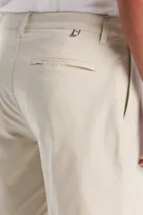 Bermuda de twill color beige, de corte clásico con bolsillos laterales y traseros, cierre frontal con botón y bragueta con cierre.