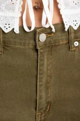 Jean de corte flare con tiro medio, confeccionado en tejido de algodón con costuras verticales decorativas en el frente.