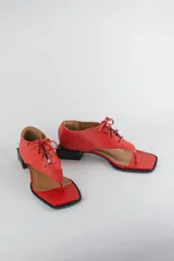 Sandalias de cuero color beige con diseño de ojota acordonada en el empeine, puntera cuadrada y taco bajo cuadrado.