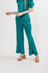 Pantalón negro de seda con tiro alto, corte recto, pinzas en la pretina y tajos en el ruedo.