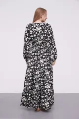 Vestido largo de poliéster con estampado floral en blanco y negro, escote en V, corte imperio con punto smock en la cintura y mangas largas con puños elásticos.