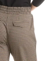 Pantalón de corte recto con estampado de cuadros tipo gales, confeccionado en mezcla de rayón, poliéster y elastano. Presenta cintura elastizada con lazo de ajuste negro, bolsillos laterales inclinados y bolsillos traseros simulados.