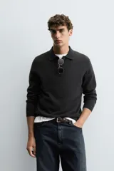 Polo de punto de corte regular fit, confeccionado en una mezcla de lana y cashmere. Presenta cuello solapa con cierre frontal de dos botones, manga larga y terminaciones en rib.