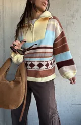 Sweater de tejido de punto con diseño a rayas horizontales y motivos geométricos, cuello alto con cierre frontal parcial, mangas largas abullonadas y puños acanalados.