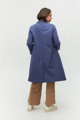 Tapado de paño azul con diseño de doble botonadura, solapas amplias y corte recto. Cuenta con bolsillos laterales discretos y forro interior.