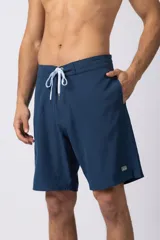 Short de baño azul marino, de corte recto y largo a la rodilla, con cordón de ajuste blanco en la cintura y bolsillo lateral con etiqueta cuadrada con logo.