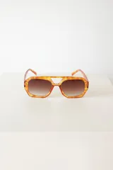 Lentes de sol con armazón de policarbonato en estampado carey y puente superior recto. Cuentan con cristales degradados en tono marrón y protección UV400.