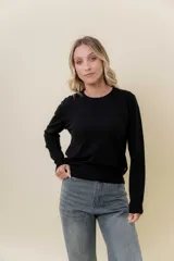 Buzo de punto color beige melange, de manga larga, cuello redondo y corte recto.