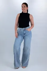 Pantalón wide leg de denim celeste claro, con costuras deflecadas y detalles deshilachados en la cintura y el remate de las piernas.