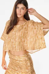 Blusa cropped de lino italiano, con diseño holgado, mangas cortas amplias y escote redondo, con estampado de rayas verticales difuminadas en tonos tostados y blancos.
