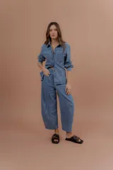 Chaqueta de jean estilo camisera, confeccionada en 100% algodón de color azul, con bolsillos frontales con solapa y cierre de botones metálicos.