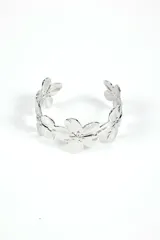 Brazalete rígido plateado con diseño de flores.