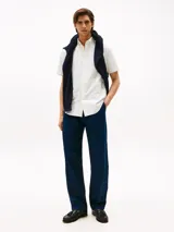 Camisa blanca de corte regular, confeccionada en algodón Oxford con cuello abotonado, manga corta y logo de Tommy Hilfiger bordado en el pecho.