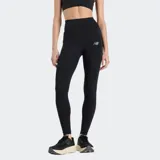 Calza deportiva New Balance de tiro alto, color negro, con tecnología NB DRY para absorción de sudor. Presenta bolsillos laterales y logo de la marca en la pierna.