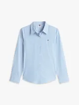 Camisa de corte regular confeccionada en popelín de algodón elástico con diseño de rayas verticales finas en color celeste y blanco. Presenta cuello clásico, cierre frontal con botones y logo de la marca bordado en el pecho.