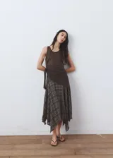 Falda midi evasé de tiro medio, con estampado de cuadros, bajo asimétrico y cierre de cremallera lateral. Cuenta con forro interior.
