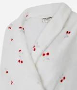 Bata de baño de corte regular confeccionada en tejido fleece de tacto suave y aspecto peludo. Presenta diseño de manga larga, abertura frontal con lazo ajustable en la cintura y bolsillos laterales. Cuenta con un estampado integral de cerezas sobre fondo blanco.