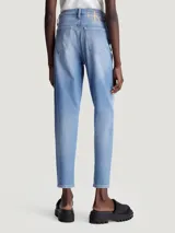 Jeans vintage de talle alto con pierna estrecha en el tobillo, confeccionados con denim de algodón elástico y fibras recicladas. Diseño de cinco bolsillos, bragueta con cremallera, lavado azul claro y bordado de Calvin Klein en la parte trasera de la cintura.