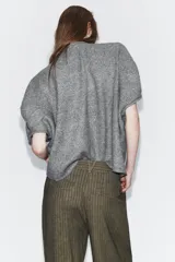 Jersey de punto liso con escote redondo y manga corta, de corte amplio y holgado.