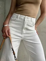 Pantalón capri blanco de tiro alto, corte recto y detalle de costuras onduladas en los bolsillos delanteros.