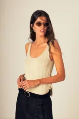 Musculosa de tejido canalé color crema, confeccionada en 100% algodón, con escote redondo y calce que acompaña el cuerpo.